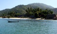 Traditional Puerto Vallarta, Jalisco, Mexico. Fishing boat, beach, jungle, thatch roofs and sunny days.