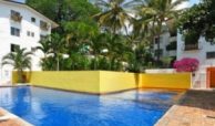Common swimming pool and condo buildings with green gardens in Loma del Mar, Puerto Vallarta condos for sale.