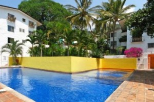 Common swimming pool and condo buildings with green gardens in Loma del Mar, Puerto Vallarta condos for sale.