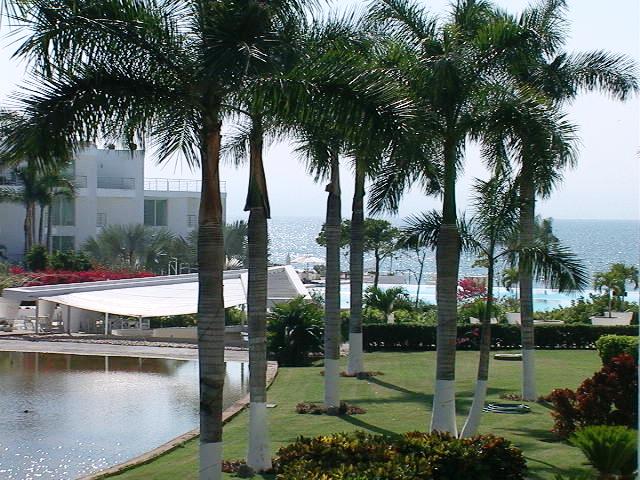 View of the pond, huge infinity pool and bay of Banderas on a sunny day in Acqua Riviera Nayarit.