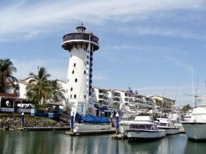 Marina Vallarta's boardwalk, lighthouse, condos on a sunny day. Perfect for active retirement living.