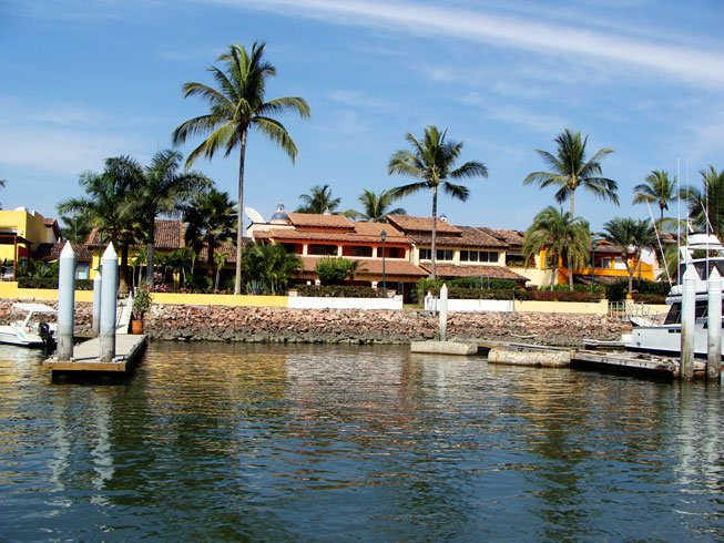 Marina front homes with pier on a sunny day in Puerto Vallarta.