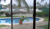 View of boat slips, yachts, private swimming pool from living area of Puerto Vallarta home for sale by owner example.