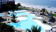 Beachfront swimming pool in Flamingos Beach and Golf Riviera Nayarit on a sunny day.