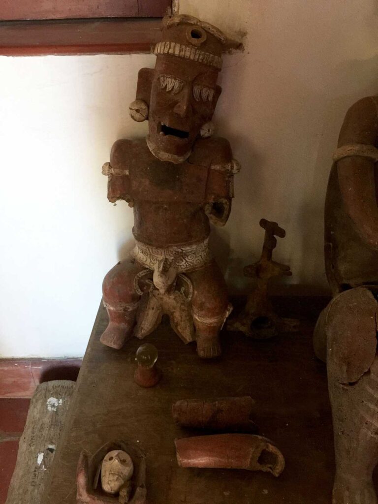 old man sculpture made of red clay found in ruins in puerto vallarta